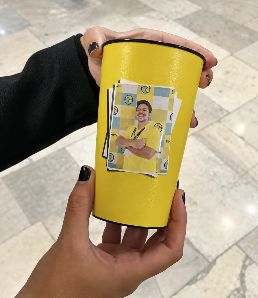 Participante segurando o SelfieCup Premium com a foto colorida impressa