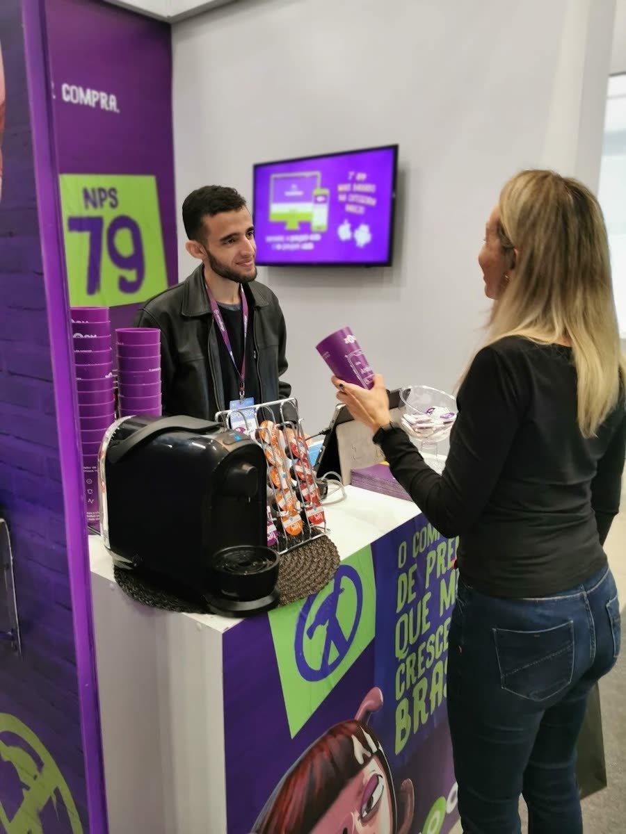 Balcão do SelfieCup Tradicional em estande de feira, com o promotor entregando o copo